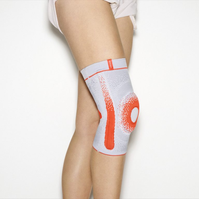 GENU-HiT SUPREME medical knee brace in grey 3D flat knit featuring a contoured silicone patella pad and lateral stabilising springs for osteoarthritis relief.