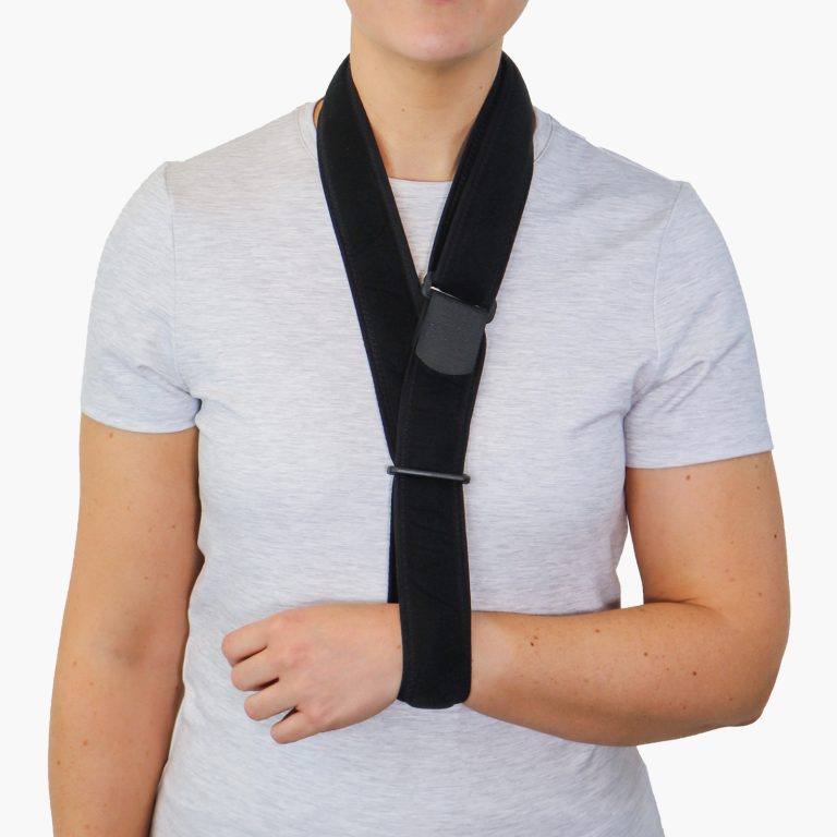 A person wearing a breathable, black Velfoam Collar & Cuff arm support over a grey t-shirt, showing the adjustable loop system.