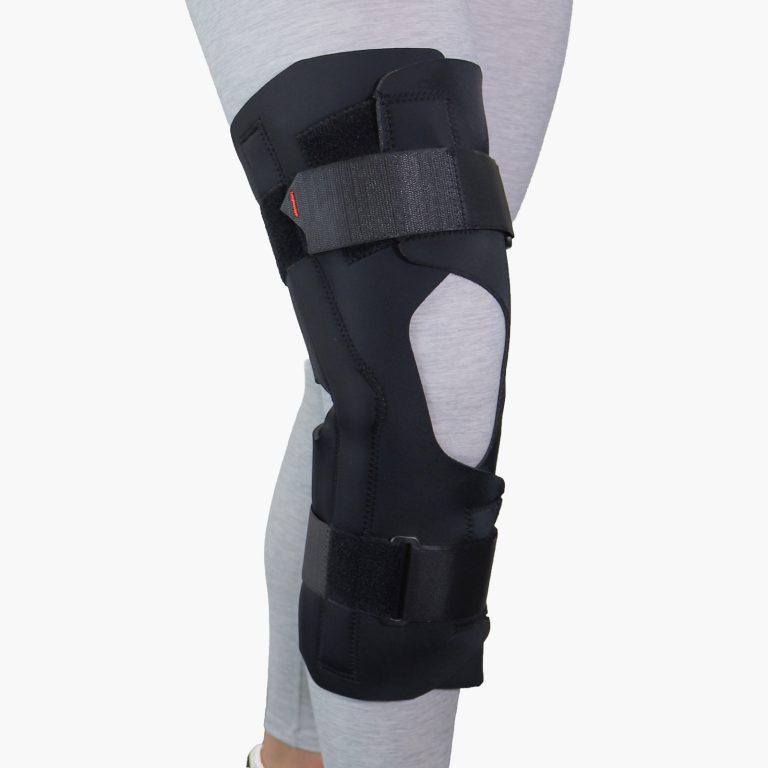 A person wearing the black TheraCore® Wraparound Knee Long brace, featuring an extended design for enhanced stability and targeted compression on the knee.